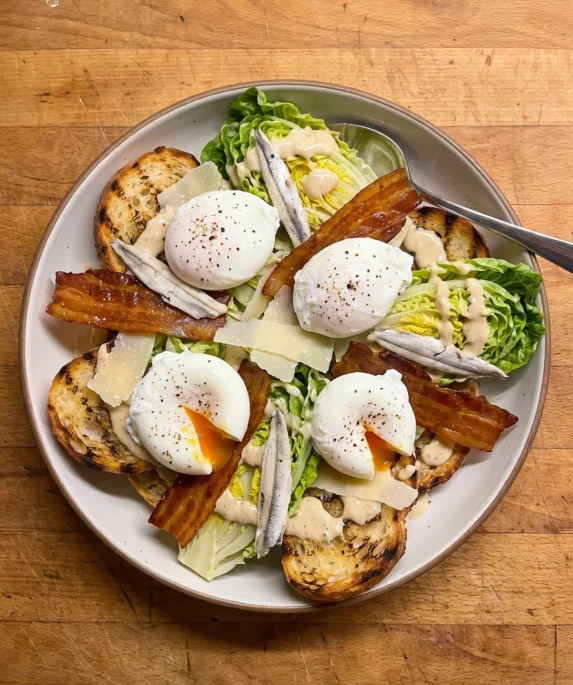 Gordon Ramsay Caesar salad with quartered baby gem lettuce, poached eggs, crisp pancetta, white anchovies and Parmesan on toasted ciabatta