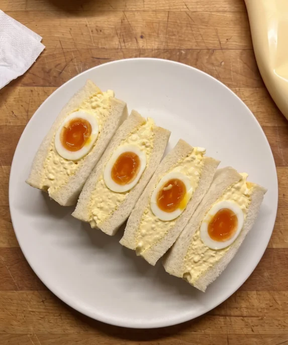 Gordon Ramsay egg salad: crustless Japanese egg salad sandwiches on milk bread, cut to show the sieved egg filling and jammy egg halves