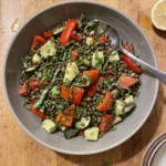 Gordon Ramsay lentil salad: dark Puy lentils with roasted red pepper and zucchini, red semi-dried tomatoes, pale green avocado cubes, chives and basil in a wide bowl