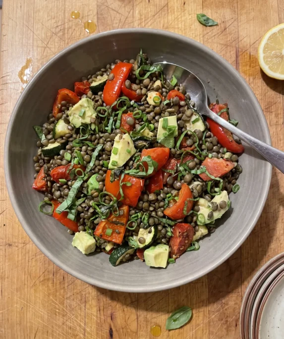 Gordon Ramsay lentil salad: dark Puy lentils with roasted red pepper and zucchini, red semi-dried tomatoes, pale green avocado cubes, chives and basil in a wide bowl
