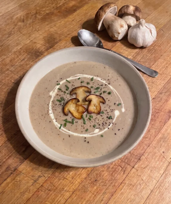 Gordon Ramsay mushroom soup: a bowl of smooth, creamy light-brown cep and garlic soup with a swirl of cream and a few caramelized cep slices