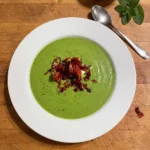 Gordon Ramsay pea and mint soup: a bowl of bright green pea soup with a dollop of crème fraîche and crispy Parma ham