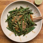Gordon Ramsay peanut butter green beans: blistered green beans with garlic in a soy peanut dressing topped with toasted sesame seeds