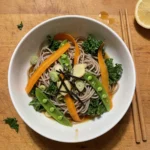 Gordon Ramsay soba noodle salad: brown buckwheat soba noodles with orange carrot ribbons, green sugar snap peas, dark kale, scallions and strips of nori in a white bowl