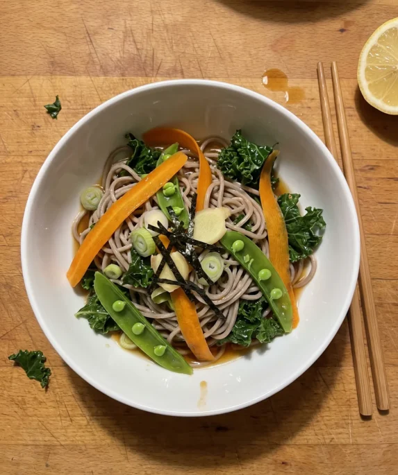 Gordon Ramsay soba noodle salad: brown buckwheat soba noodles with orange carrot ribbons, green sugar snap peas, dark kale, scallions and strips of nori in a white bowl