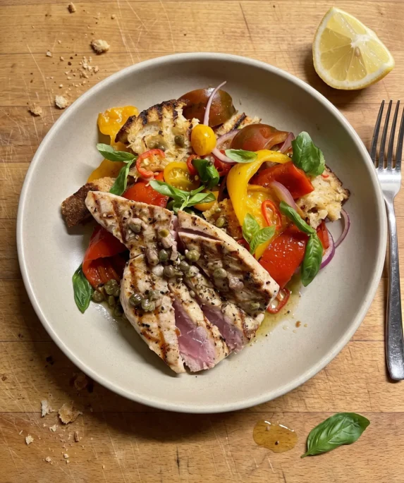 Gordon Ramsay tuna salad: sliced seared tuna steak, rare in the middle, over a panzanella of torn toasted sourdough, heirloom tomatoes, roasted peppers, red onion and basil with capers